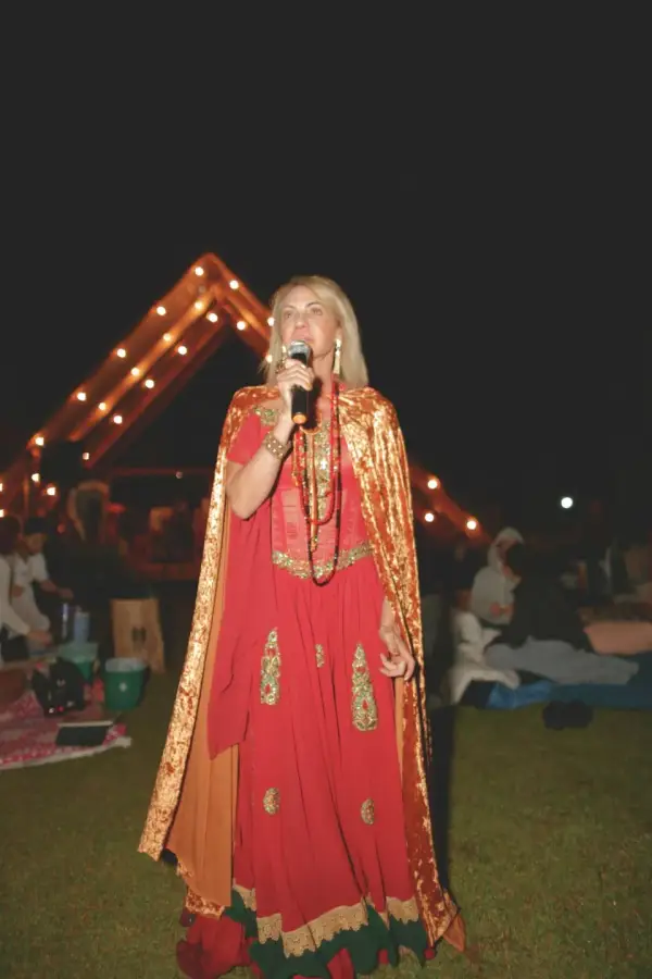 Valéria Tavares cantando ao microfone durante um ritual noturno