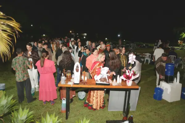 Participantes reunidos no gramado em frente ao altar